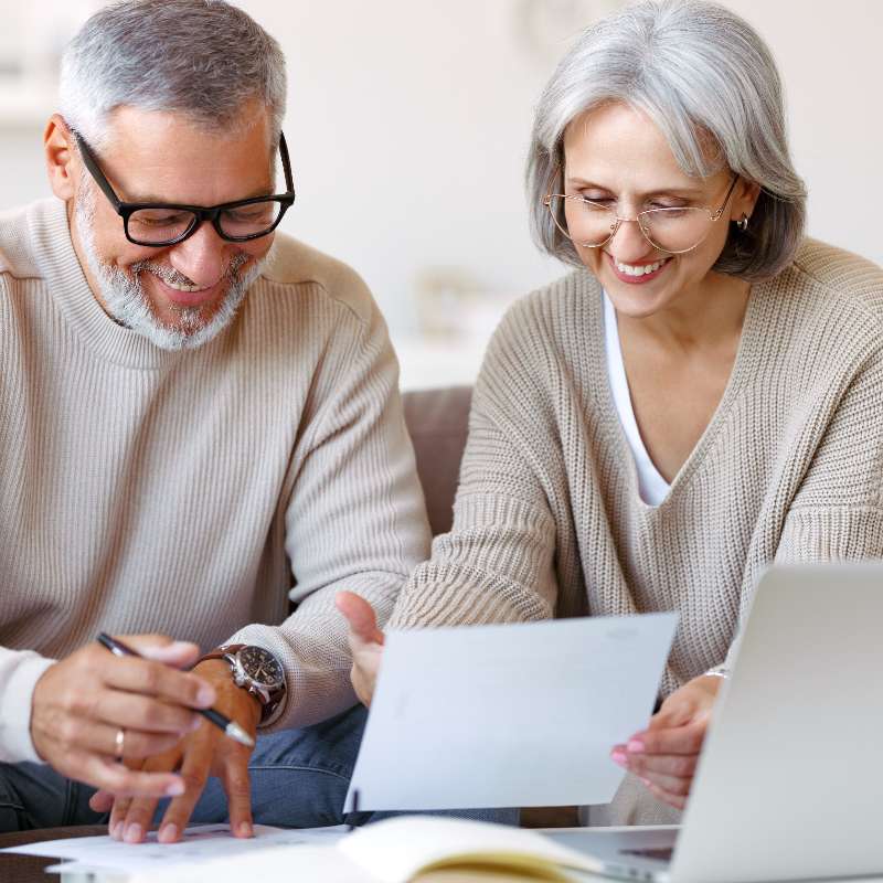 Pareja sonriente leyendo documentos